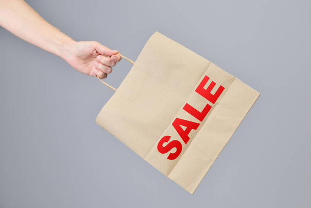 Sale- Paper shopping bag in woman's hand. - Foto, imagen