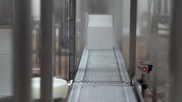 Movement of conveyor belt with two white cardboard boxes on it - Materiał filmowy, wideo