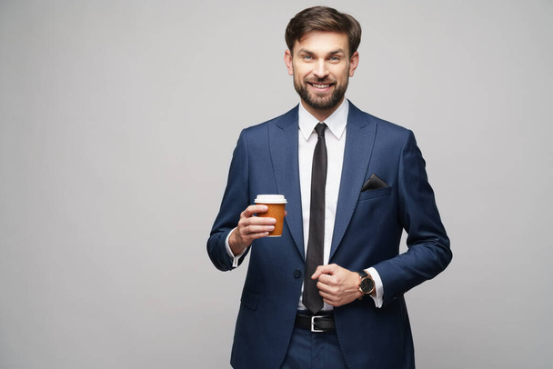 Young caucasian Businessman holding takeout paper cup coffee - Foto, imagen