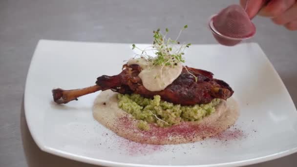 De chef-kok versiert met kruiden met een geroosterd vogelpoot, eenden. Close-up actie van de handen - Video