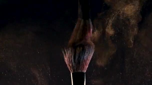 Two makeup brushes with bright eye shadow. Glitter and shadows scatter in the air - Felvétel, videó