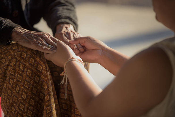 Yaşlılarla yakından ilgilenen yaşlı kadınların ve genç kadınların elleri.. - Fotoğraf, Görsel