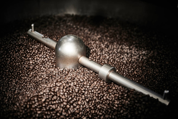 Freshly roasted coffee beans in a coffee roaster.Frozen moment - Photo, Image