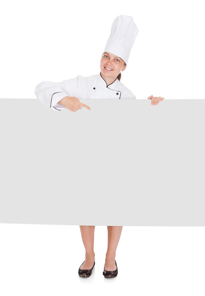 Chef mujer señalando en cartel en blanco
 - Foto, Imagen