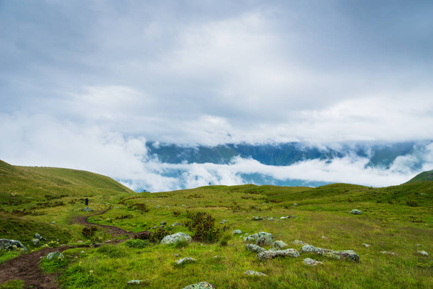 Kazbegi, Georgia - Mount Kazbegi landscape with dramatic clouds up in the trekking and hiking route. - Foto, imagen