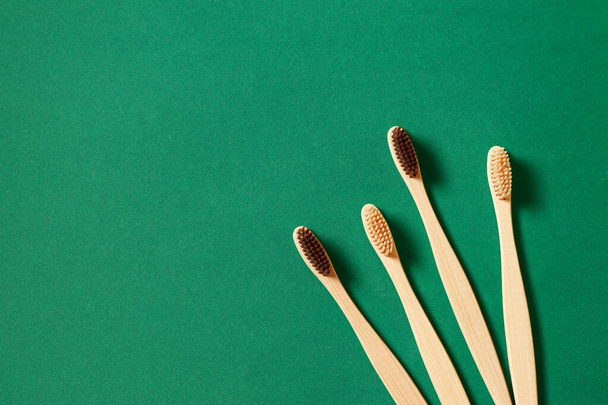 Vue de dessus ou concept de pose à plat avec brosses à dents éco en bambou sur fond vert
 - Photo, image