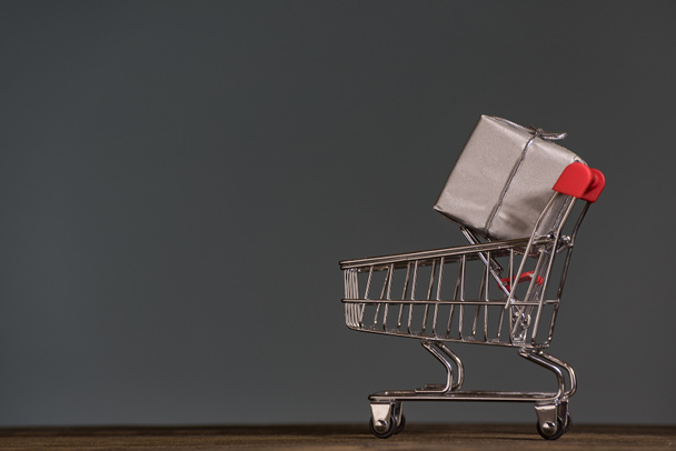 Shopping trolley with a gift. Season of sales and discounts. Holiday concept. - Foto, immagini