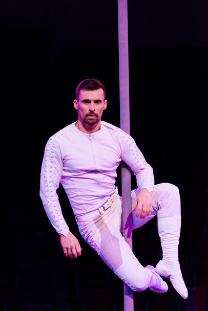 handsome acrobat looking at camera while performing isolated on black  - Photo, Image
