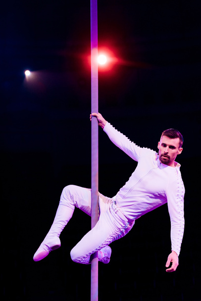 acrobat looking away while performing on black near back light  - Foto, imagen