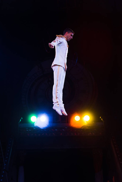 vue latérale du beau gymnaste en costume sautant dans l'arène du cirque
  - Photo, image