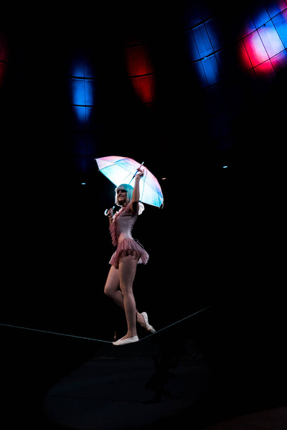 boldog légi akrobata jelmez gazdaság esernyő és álló kötél  - Fotó, kép
