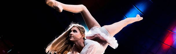panoramic shot of flexible girl in costume performing in arena of circus  - Foto, Imagen