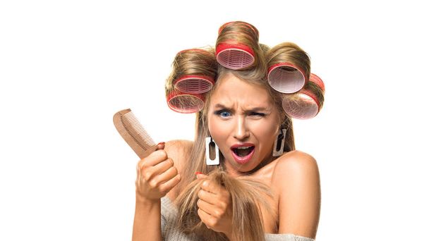 Egy frusztrált nő portréja hajcsavarókkal a fején. - Fotó, kép