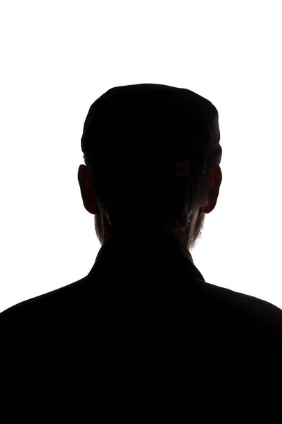 Old man in peaked cap, rear view - dark close-up silhouette - Photo, Image