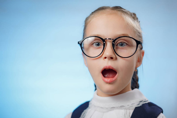 Aranyos kis iskoláslány szemüveget visel a Blue Backroundon. Az iskolai oktatás koncepciója. Gyerek kocka. Portré Közelkép - Fotó, kép