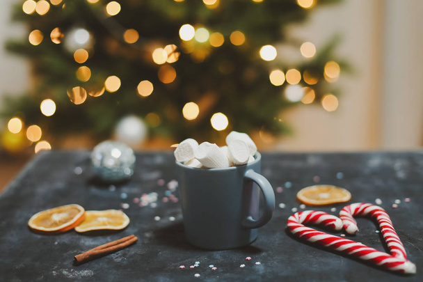 Cup with marshmallows, candy cane, tangerines.  New Year still life. Christmas tree. Christmas, winter, New year concept. Flat lay - Фото, изображение