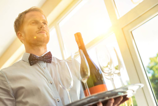 Atractivo camarero con botella de champán - Foto, imagen