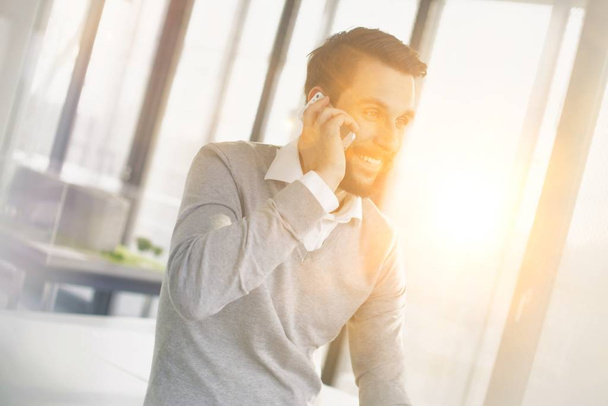 Attractive business man making a telephone call in the office - 写真・画像