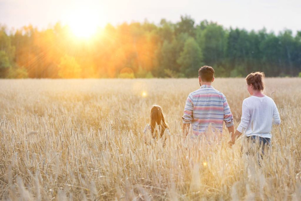 Rear view of family walking amidst crops at farm - Fotografie, Obrázek