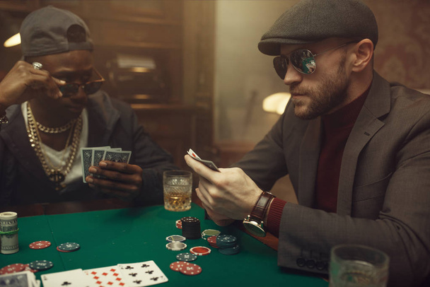 Pokerinpelaaja tuntee riskin, kasino. Sattumariippuvuuden pelit. Mies, jolla on kortteja käsissä vapaa-ajan uhkapeli talossa
 - Valokuva, kuva