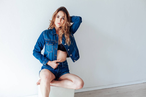 portrait of a beautiful fashionable woman in a denim jacket and shorts - Photo, Image