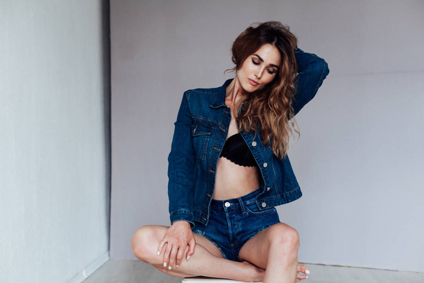 portrait of a beautiful fashionable woman in a denim jacket and shorts - Foto, Imagem