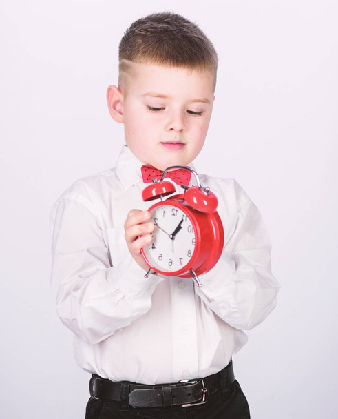 tuxedo kid. Happy childhood. Party time. Businessman. Formal wear. Time management. Morning. little boy with alarm clock. Time to relax. happy child with retro clock in bow tie. what time is it - Foto, afbeelding