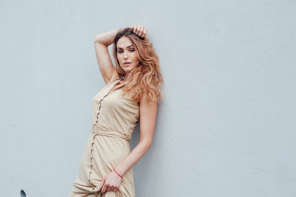 Portrait of a beautiful fashionable woman in a beige light dress - Photo, Image