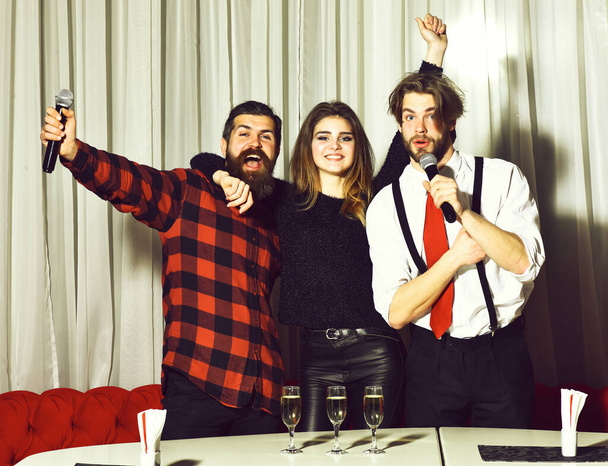 Happy friends celebrating at karaoke party on white curtain - Zdjęcie, obraz