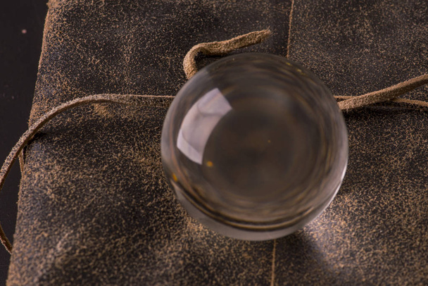 bola de vidro místico em um livro com capa de couro velho
 - Foto, Imagem