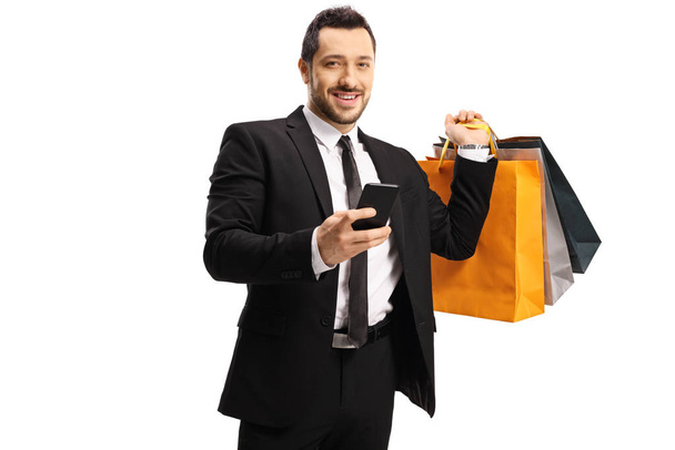 Businessman with shopping bags and a smartphone - Photo, Image