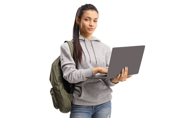 Cute female student holding a typing on a laptop and looking at  - Fotó, kép