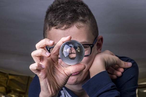 Jung emettere occhiali guarda in una palla di vetro per il futuro
 - Foto, immagini