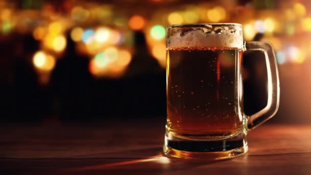 glass beer mug on the bar counter with copy space on blurred lights background - Footage, Video