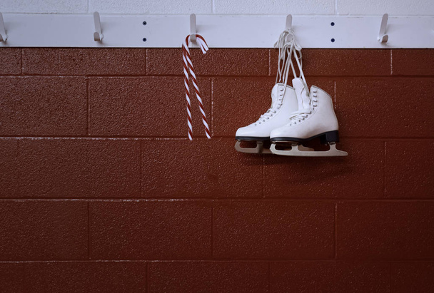 Fondo de Navidad de patines con bastón de caramelo colgando sobre la pared roja con espacio de copia
 - Foto, Imagen