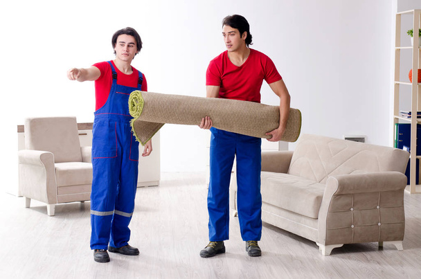 Two young contractor employees moving personal belongings - Foto, afbeelding