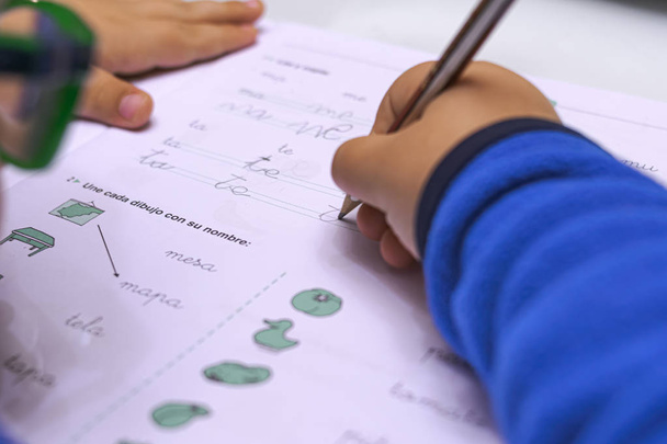 Kind lernt in der Schule schreiben und Hausaufgaben machen - Foto, Bild
