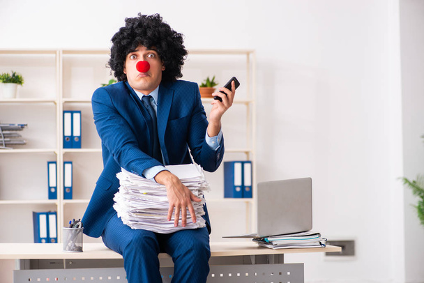 Jonge clown zakenman werkt in het kantoor - Foto, afbeelding