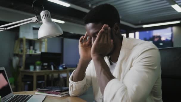 Közelkép a stresszes alkalmi afro-amerikai üzletember fejfájással Laptopos munka, kamera csúszkálás - Felvétel, videó