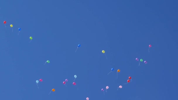 kauniit värilliset ilmapallot lentävät taivaalla, punainen sininen keltainen oranssi vaaleanpunainen. Monet värikkäät ilmapallot lentävät ilmassa. Juhla ja syntymäpäivä konsepti. Käsite kaunis loma
. - Materiaali, video