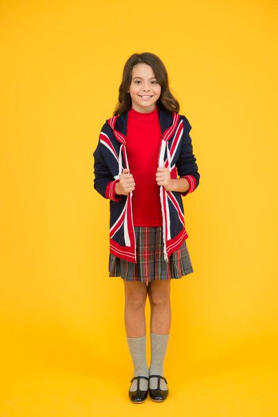 patriotic kid with english flag on jacket. go study to england. learn english language. british school in england. vacation in great britain. travel concept. Union Jack Flag. small girl uniform - Photo, Image