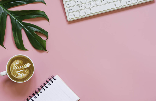 Een kopje koffie met toetsenbord en kopieer ruimte op roze achtergrond. - Foto, afbeelding