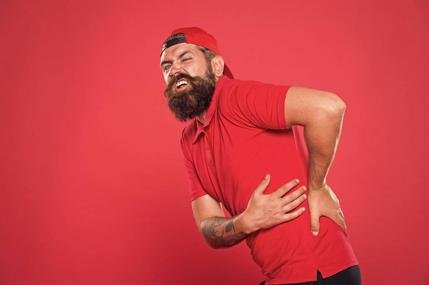 Guy feel pain in back. Healthcare and injuries concept. Sedentary lifestyle. Trauma and treatment. Exercises for back. My back hurts. Man painful face touches lower back. Problems with health - Foto, Imagem