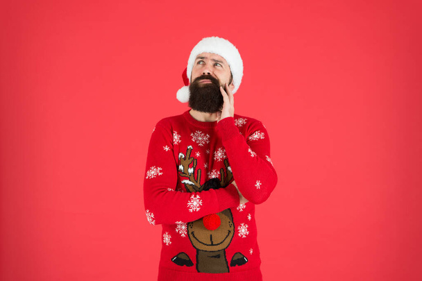 Get Guaranteed Christmas Delivery. winter holiday celebration. dreaming present. bearded man santa hat red wall. christmas time. male at xmas party. happy new 2020 year. funny hipster knitted sweater. - Foto, Imagem