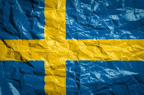 Flaga Szwecji na pogniecionym papierze. Flaga wydrukowana na arkuszu. Wizerunek flagi na ulotkach, reklama. - Zdjęcie, obraz