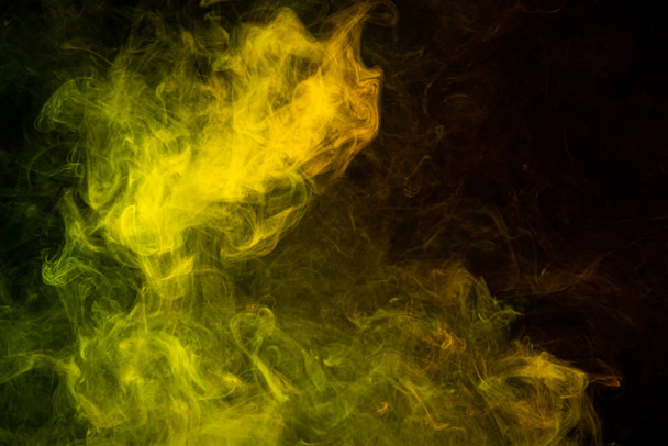 Wzór, neonowy żółty i pomarańczowy dym w ciemnym odizolowanym tle. Tło od dymu vap - Zdjęcie, obraz