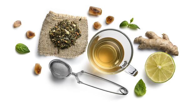 Groene thee met natuurlijke aromatische toevoegingen en accessoires. Bovenaanzicht op witte achtergrond - Foto, afbeelding