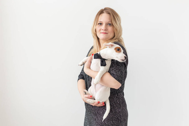Domácí mazlíčci a zvířecí koncept - Hezká žena se štěňátkem Jack Russell teriér na bílém pozadí s copyspace - Fotografie, Obrázek