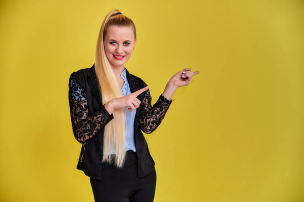 Portrait of a manager woman in a business suit with long beautiful hair and excellent make-up on a yellow background. Concept business blonde girl stands in front of the camera. - Foto, Bild
