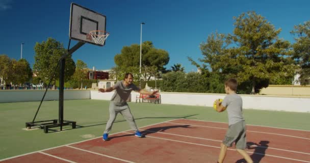 Zoon oefenen passeren basketbal met vader. - Video